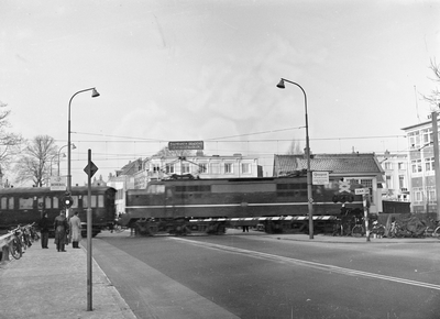 834805 Gezicht op de met automatische halve overwegbomen (AHOB's) beveiligde spoorwegovergang in de Biltstraat te ...